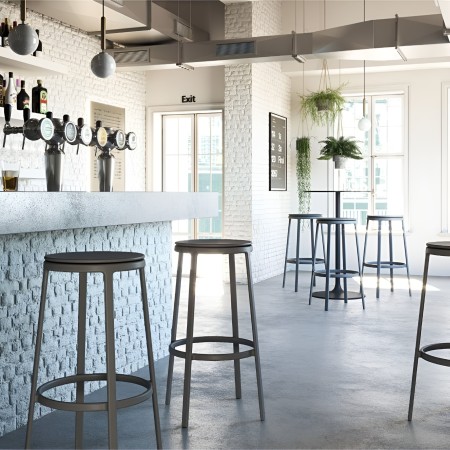 Tabourets hauts ROUND&ROUND noirs avec assise fixe dans un bar moderne et lumineux