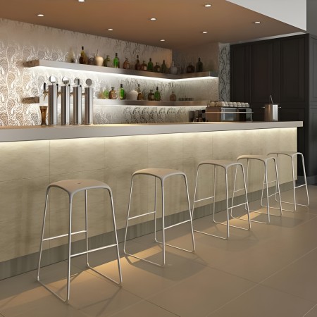 Tabourets Bobo blancs devant un bar moderne avec éclairage intégré – usage professionnel ou résidentiel