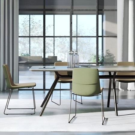 Table ARQUS avec chaises TWIST&SIT vertes dans salle de réunion design lumineuse