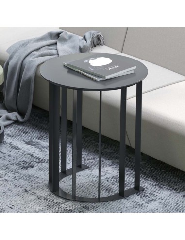Table basse ronde noire avec pieds design en métal dans salon moderne avec canapé gris