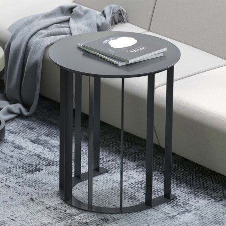 Table basse ronde noire avec pieds design en métal dans salon moderne avec canapé gris