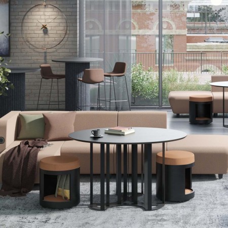 Salon lounge avec table basse ronde noire, tabourets marron et canapé beige moderne