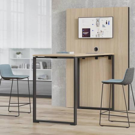 Espace coworking chaleureux avec table haute bois clair et écran mural MEDIA