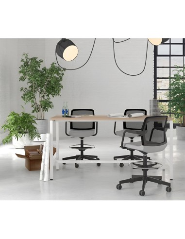 Table de réunion en bois clair avec chaises à roulettes et plantes vertes en bureau lumineux