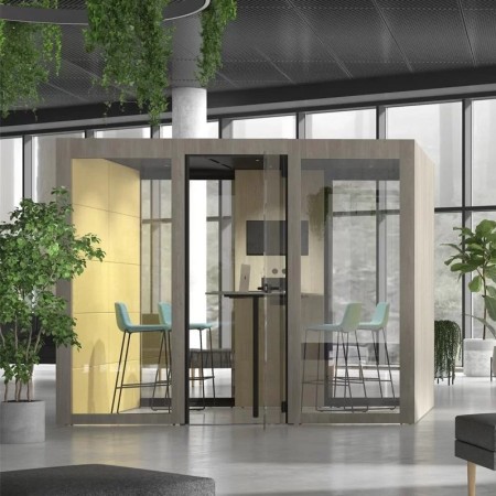 Cabine acoustique vitrée en bois avec chaises hautes bleues dans espace de coworking