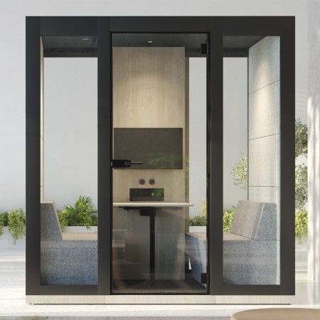 Cabine acoustique vitrée avec 2 fauteuils, une table et un écran mural intégré