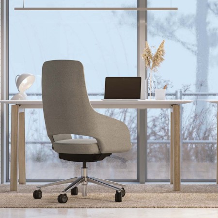 Fauteuil Sandie dossier haut beige devant un bureau avec vue extérieure