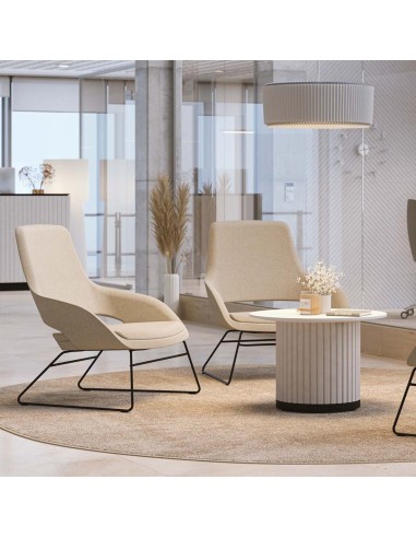 Fauteuil lounge beige en tissu dans un espace lumineux avec table basse en bois