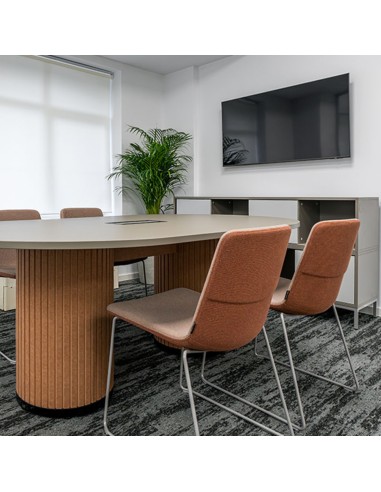 Chaises TWIST&SIT en tissu orange avec piètement luge gris autour d’une table de réunion ovale