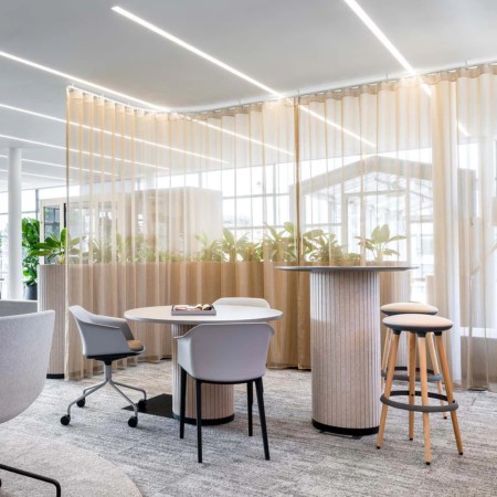 Espace lounge avec tables PARTHOS de différentes hauteurs – ambiance travail moderne