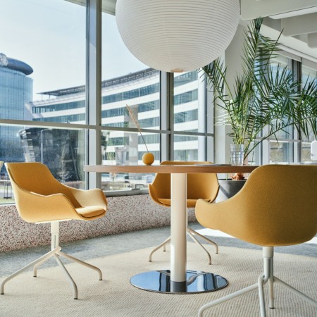 Table ronde en bois clair avec sièges de réunion jaunes