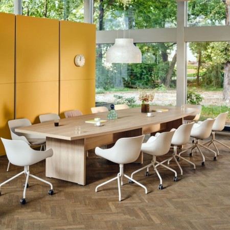 Sièges de travail blancs autour d'une grande table de conférence