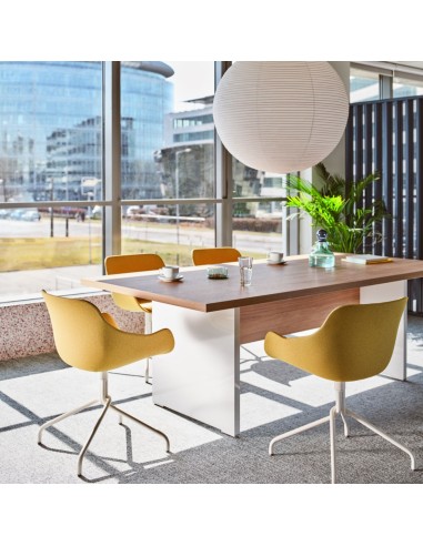 Table de réunion avec chaises jaunes et blanches dans une salle lumineuse