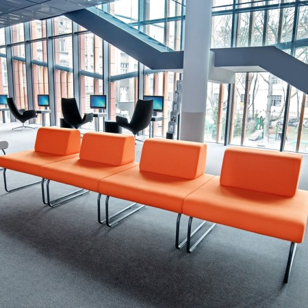Banquette Legvan orange alignée dans espace public