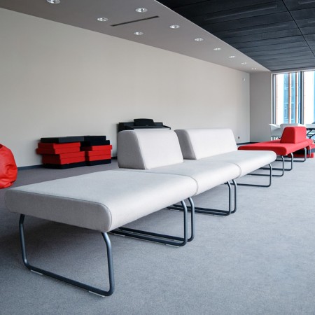 Banquettes Legvan grises et rouges associées à des tables basses modernes - Legvan