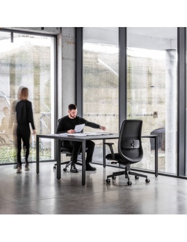 Chaise Belt BE 102 noire dans un bureau moderne avec grandes baies vitrées