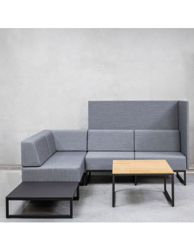 Un ensemble modulaire gris clair comprenant des assises Plint associées à une table basse en bois clair, formant un coin détente