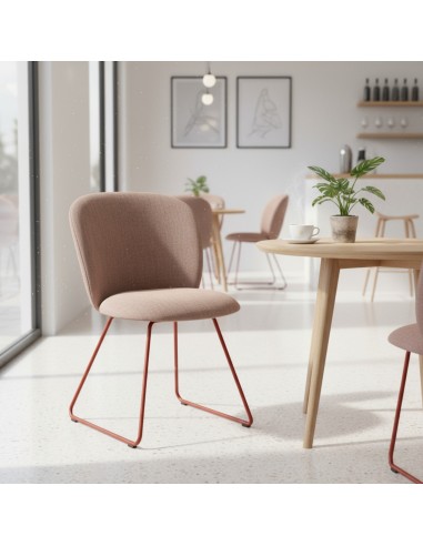 Chaise Volta avec assise tapissée rose poudré et piètement métallique cuivré, intégrée dans un café lumineux à la décoration sca