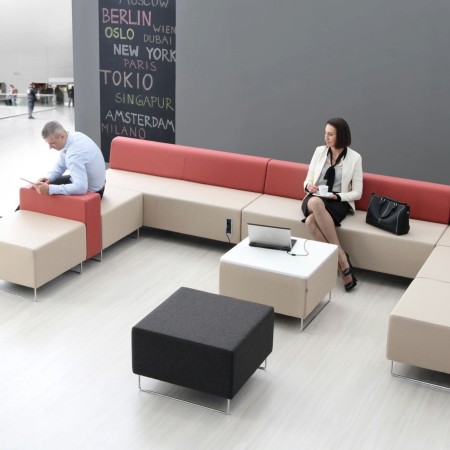 Espace lounge dynamique avec banquettes rouges et accessoires noirs. - Quadra