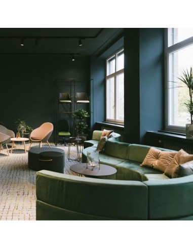 Espace lounge lumineux avec banquettes vertes et fauteuils clairs. - Quadra