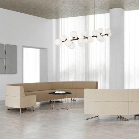 Salle claire avec banquettes modulaires beiges et table en bois. - Quadra