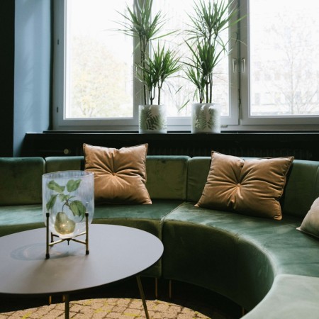 Salon contemporain avec banquettes vertes modulaires et plantes. - Quadra