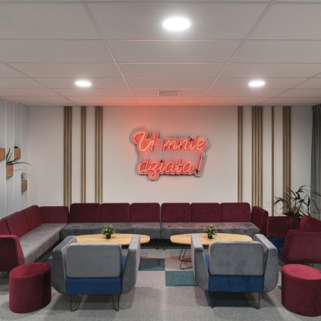 Espace convivial avec fauteuils orange et verts sur fond industriel. - U Floe