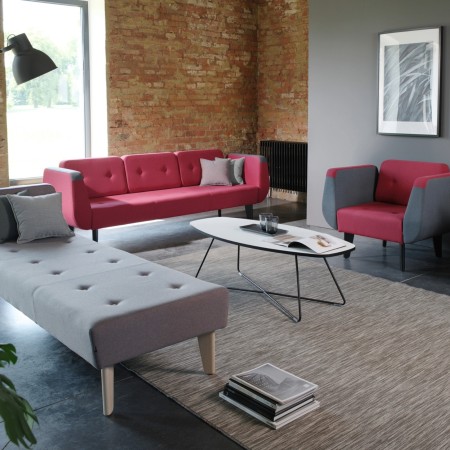 Espace design avec fauteuils rouges et gris autour d’une table basse. - U Floe
