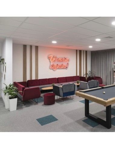 Zone détente moderne avec fauteuils rouges et ambiance chaleureuse. - U Floe