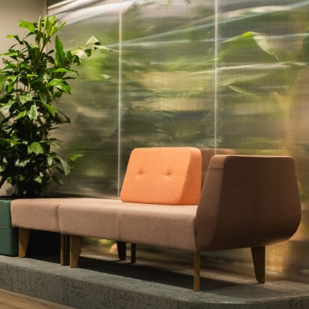 Fauteuil orange dans un salon lumineux à grandes baies vitrées. - U Floe