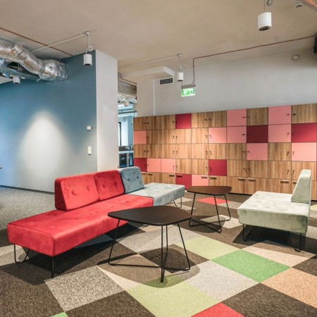 Salon coloré avec assises modulaires et tapis géométrique. - U Floe