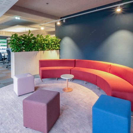 Salon convivial avec banquettes courbes et poufs Cube multicolores. - Cube