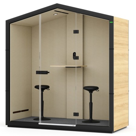 Cabine Treehouse avec structure noire, parois vitrées et tabouret haut devant la table intégrée. - Treehouse