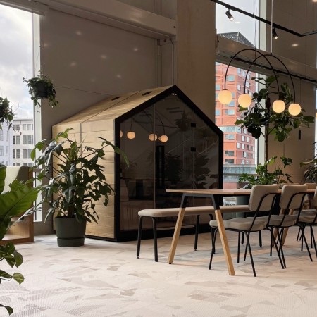 Cabine Treehouse en bois et structure noire, intégrée dans un hall lumineux avec plantes. - Treehouse 2