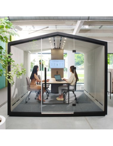 Cabine Treehouse grand format utilisée en salle de réunion informelle avec table centrale. - Treehouse