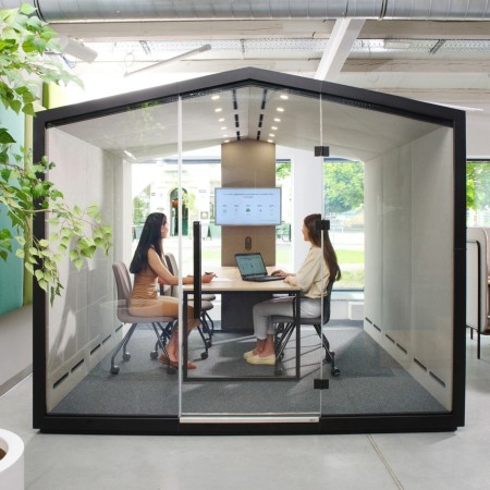 Cabine Treehouse grand format utilisée en salle de réunion informelle avec table centrale. - Treehouse