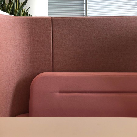 Vue rapprochée d’une banquette Fora rose, montrant le tissu texturé et les courbes douces des dossiers. - Fora