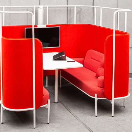 Configuration audacieuse de Fora rouge formant une alcôve dynamique pour réunions collaboratives. - Fora